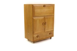 An Ercol beech cocktail cabinet