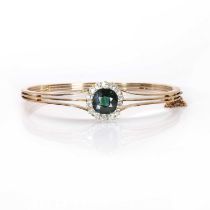 An early 20th century green sapphire and diamond cluster hinged bangle,
