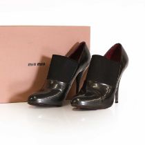 A pair of Miu Miu dark grey patent leather shoe boots,