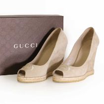 A pair of Gucci champagne suede peep toe wedge shoes,