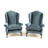 A pair of George II style wingback armchairs