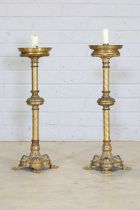 A pair of tall brass candlesticks,