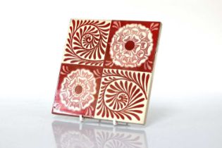 A set of twelve 'Rose and Scroll' ruby lustre tiles,