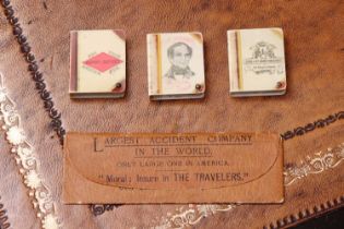 A group of three American celluloid book-form stamp boxes