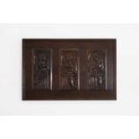 Three carved oak panels depicting saints,