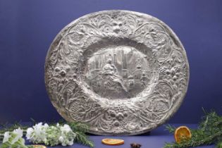 A chased silvered metal oval dish,
