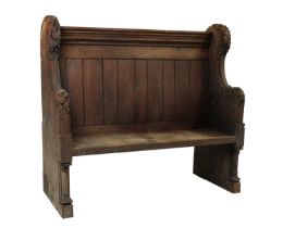A carved oak settle or pew,