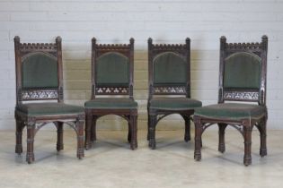A set of four Gothic oak single dining chairs