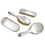 A four piece silver dressing table set