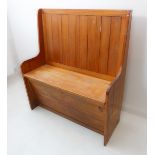 A pine settle: vertical slatted back above a hinged storage compartment (106 cm wide x 43 cm deep