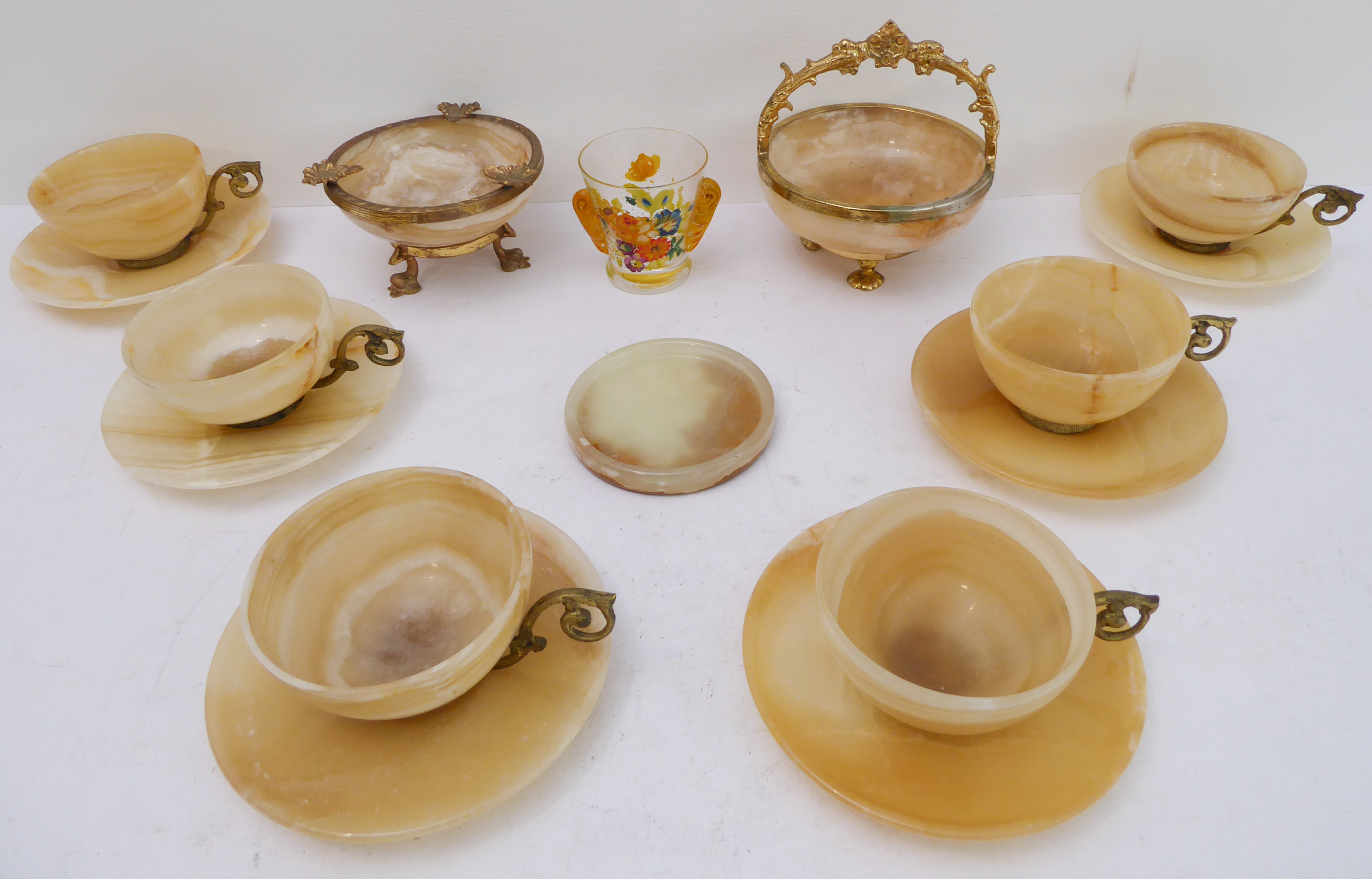 A set of six mid-20th century gilt-metal-mounted onyx cups and saucers, three other pieces of onyx