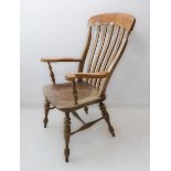 A late 19th century lathe-back open-armed armchair with shaped elm seat and turned tapering legs