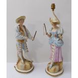 A pair of hand-decorated figural porcelain lamps (male and female): female figure with fish in
