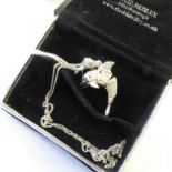 An unusual silver pendant modelled as an articulated dolphin with blue gemstone eyes, upon a