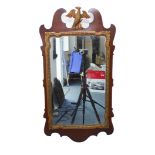 An 18th century-style (later) mahogany and parcel-gilt wall-hanging looking glass having an open-