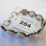 A lady's silver bracelet set with nine round cream hardstones with natural swirls