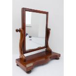 A 19th century mahogany cushion-framed swing-mirror, supported by scroll arms above a bow-shaped
