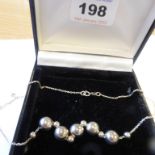 A lady's silver necklace modelled with five larger and five smaller moveable beads (boxed)