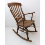 A late 19th century lathe-back rocking chair; vertical uprights and shaped arms above a shaped elm