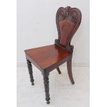A single late Regency period mahogany hall chair; carved scrolling back above a solid seat and