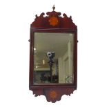 A late George III inlaid mahogany wall mirror surmounted with a gilt-metal finial and with bevel-