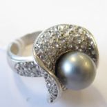 A lady's unusual silver dress ring centrally-set with a silver coloured pearl within a shaped