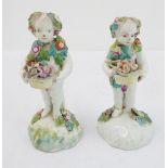 A pair of early figures as children with baskets of flowers (damages) (13.5 cm high)