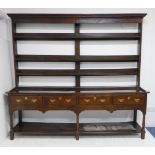 A large late 18th to early 19th century oak dresser: the shelved superstructure above four full-