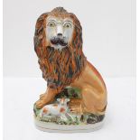 An unusual mid-19th century Staffordshire pottery model of a seated lion with a lamb recumbent