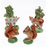 Four 19th century Staffordshire figures: two similar bocage figures of cows and calves with red
