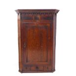 A large and stylish 18th century oak and mahogany faced hanging corner cupboard of large