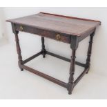 A late 17th to early 18th century oak side table: later rear short gallery; overhanging moulded top;