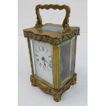 A late 19th to early 20th century French gilt-brass and glass-sided carriage clock: the shaped