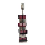 A Modernist red angular perspex and cylindrical brushed-steel table lamp (49 cm high including
