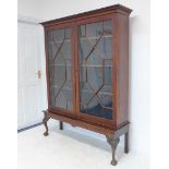 A late 18th century mahogany cabinet on later base: dentil cornice above two 13-panel doors with