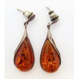 A pair of silver-mounted pear-shaped 'speckled amber' earrings
