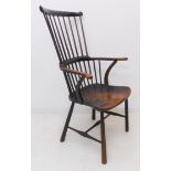 A late 18th century comb back Windsor chair: the ebonised wood, shaped outset arms above a shaped