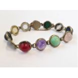 A silver bracelet mounted with various hardstones polished en-cabochon to include turquoise,