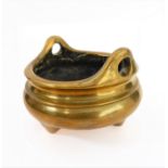 A Chinese polished brass/bronze two-handled tripod censer in 17th century style: reign marks