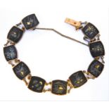 An early 20th century bracelet: the flat links inlaid with various metals and various design