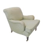 An early 20th upholstered armchair: square tapering front legs terminating in brass castors, each