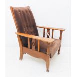 A stylish Arts and Crafts style oak reclining armchair: shaped arms above vertical splats (the