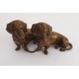 A 20th century well-patinated bronze of two seated Dachshunds, stamped 'R' to rear leg on base. (4
