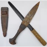 A 19th century African-style sheathed knife with carved and patinated wooden handle and hand-