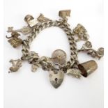 A silver charm bracelet with heart-shaped padlock: the charms to include a penny farthing, a large