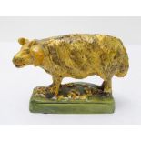 A late 18th to early 19th century Pearlware model of a ram lamb in yellow glaze and with curling