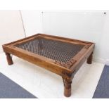 A carved Eastern-style hardwood low coffee table with iron wire mesh style centre (141cm long x 95.