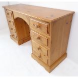 A modern pine dressing table: moulded top above central knee space flanked by four further smaller