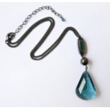 A hand-cut blue pear-shaped pendant upon a chain (boxed)