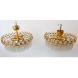 A pair of very stylish circular ceiling hanging gold-plated chandeliers: cut-glass droplets of